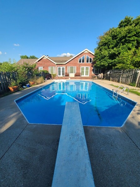 Brick house with a large pool and diving board